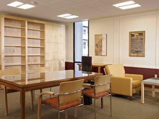 a desk, chairs, and empty bookshelves